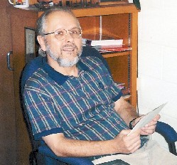 don osborn sitting in an office chair holding a paper