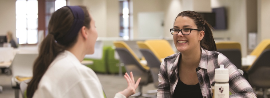 Students chat with each other at a library table