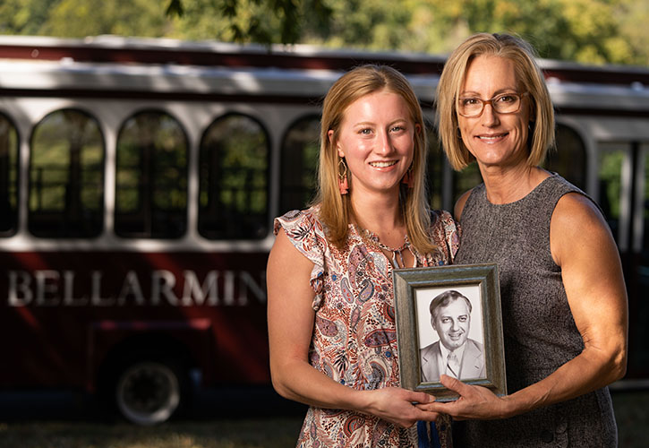 A mother and daughter holding a picture in a frame