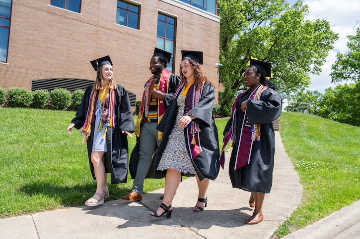 Students Walking on Campus with Cap and Gown