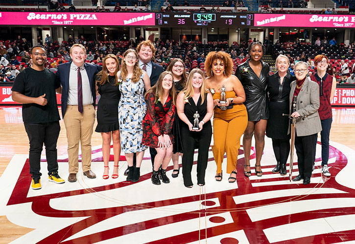 A group of students standing at half court in Knights Hall