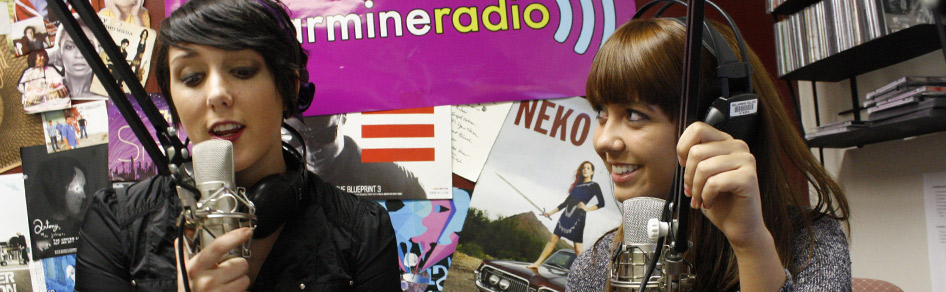 Two students broadcast from a sound studio