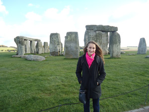 A study abroad student poses with stone henge in the background
