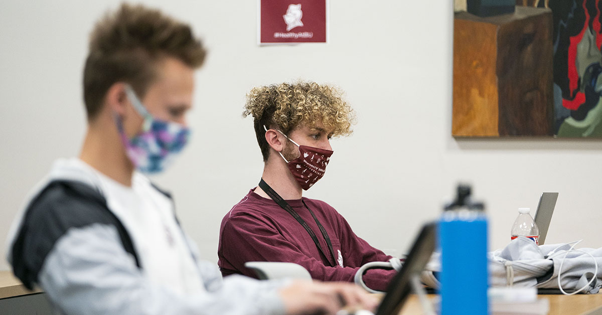 Students sitting in a classroom with masks on