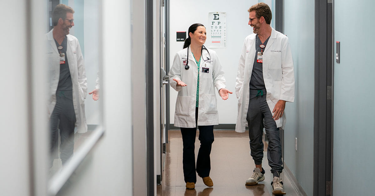 Two nurses walking down a hall