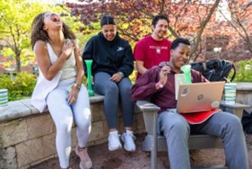 students sit outside their residence hall