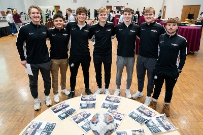 a group of student athletes pose for a group photo at an award ceremony
