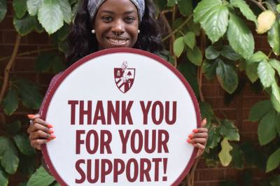 Student holds a sign that says thank you for your support