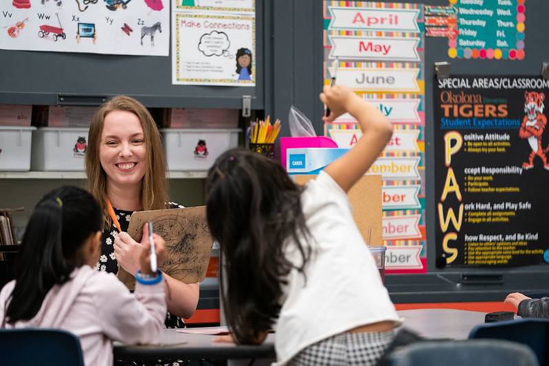 A teacher interacts with children in a classroom.