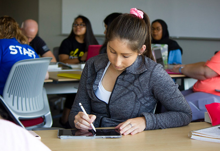 A student using a tablet to take notes in class