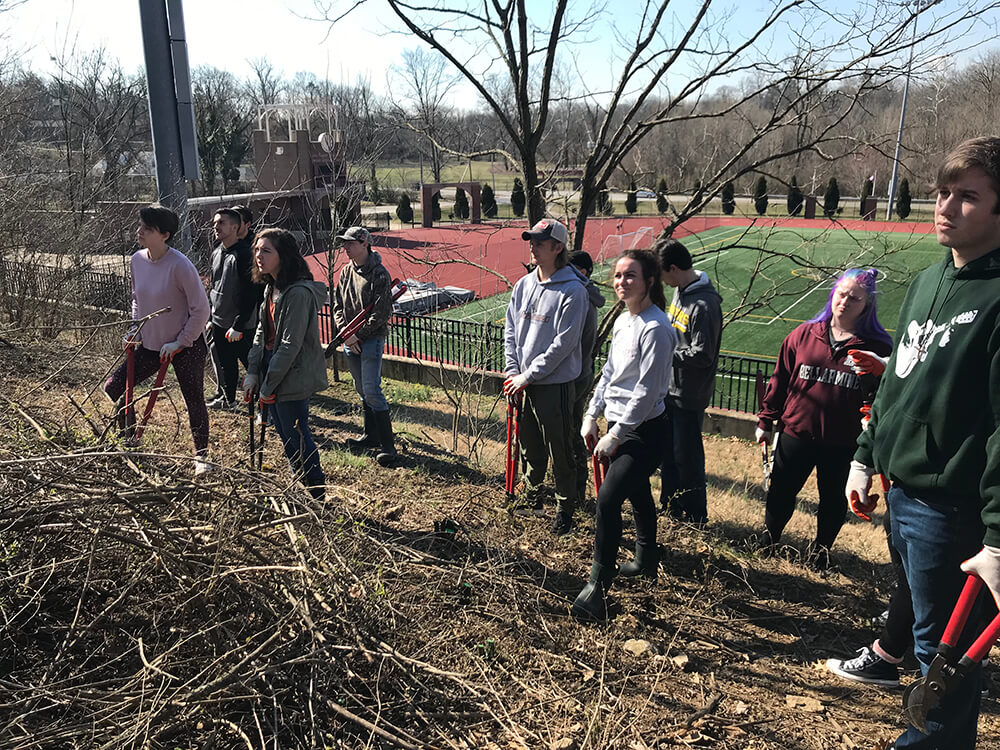 CommunityEngagement3 Students standing in a forested area at Bellarmine