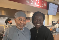 two people pose for a photo in the cafeteria